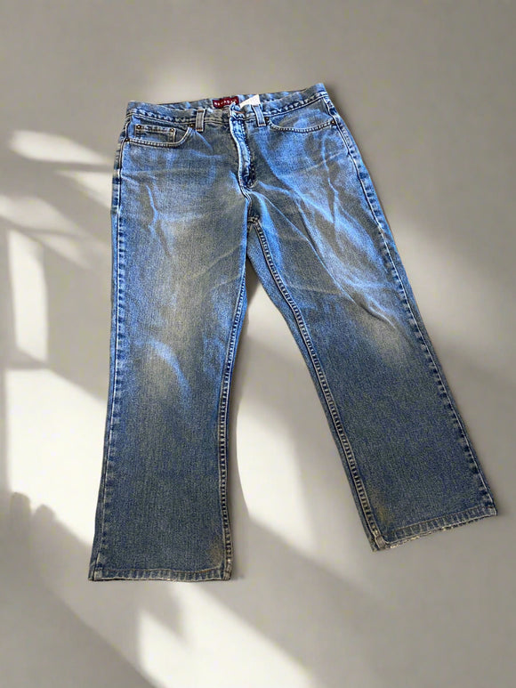 Pair of blue jeans laid flat on a beige surface