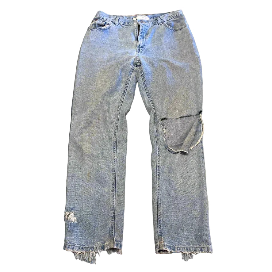 Pair of light blue jeans on a textured brown surface