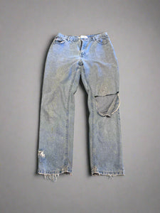 Pair of light blue jeans on a textured brown surface