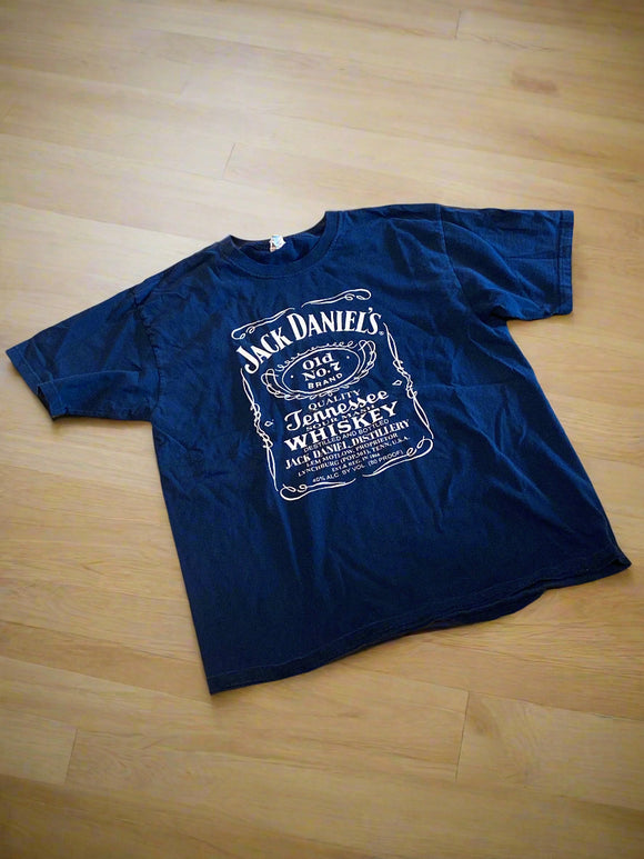Navy blue t-shirt with Jack Daniel's logo on a beige surface