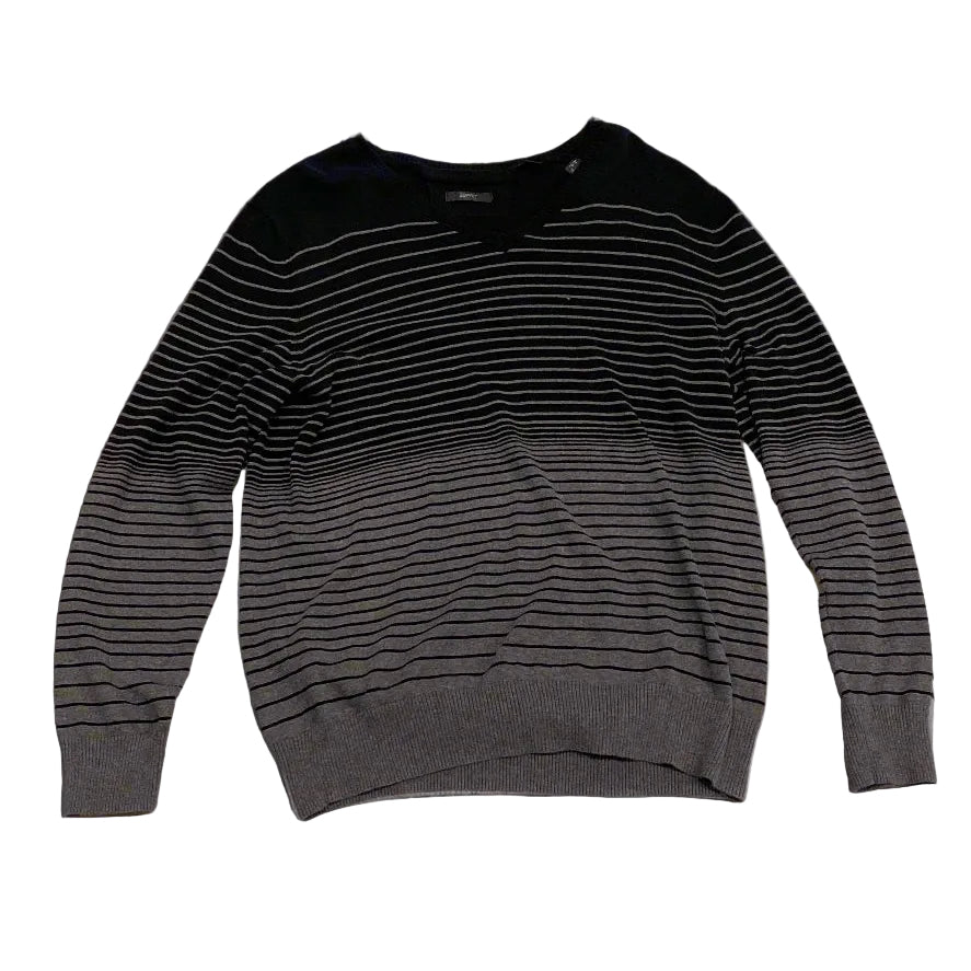 Black long-sleeve shirt on a textured beige surface
