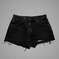 Black denim shorts on a concrete floor