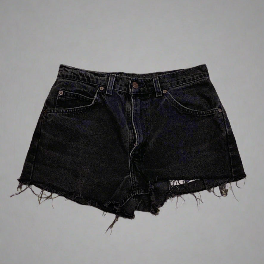 Black denim shorts on a concrete floor