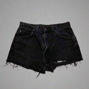 Black denim shorts on a concrete floor