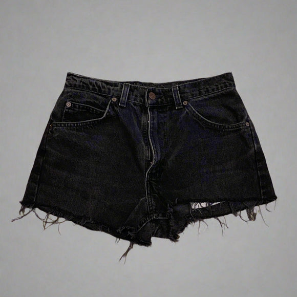 Black denim shorts on a concrete floor